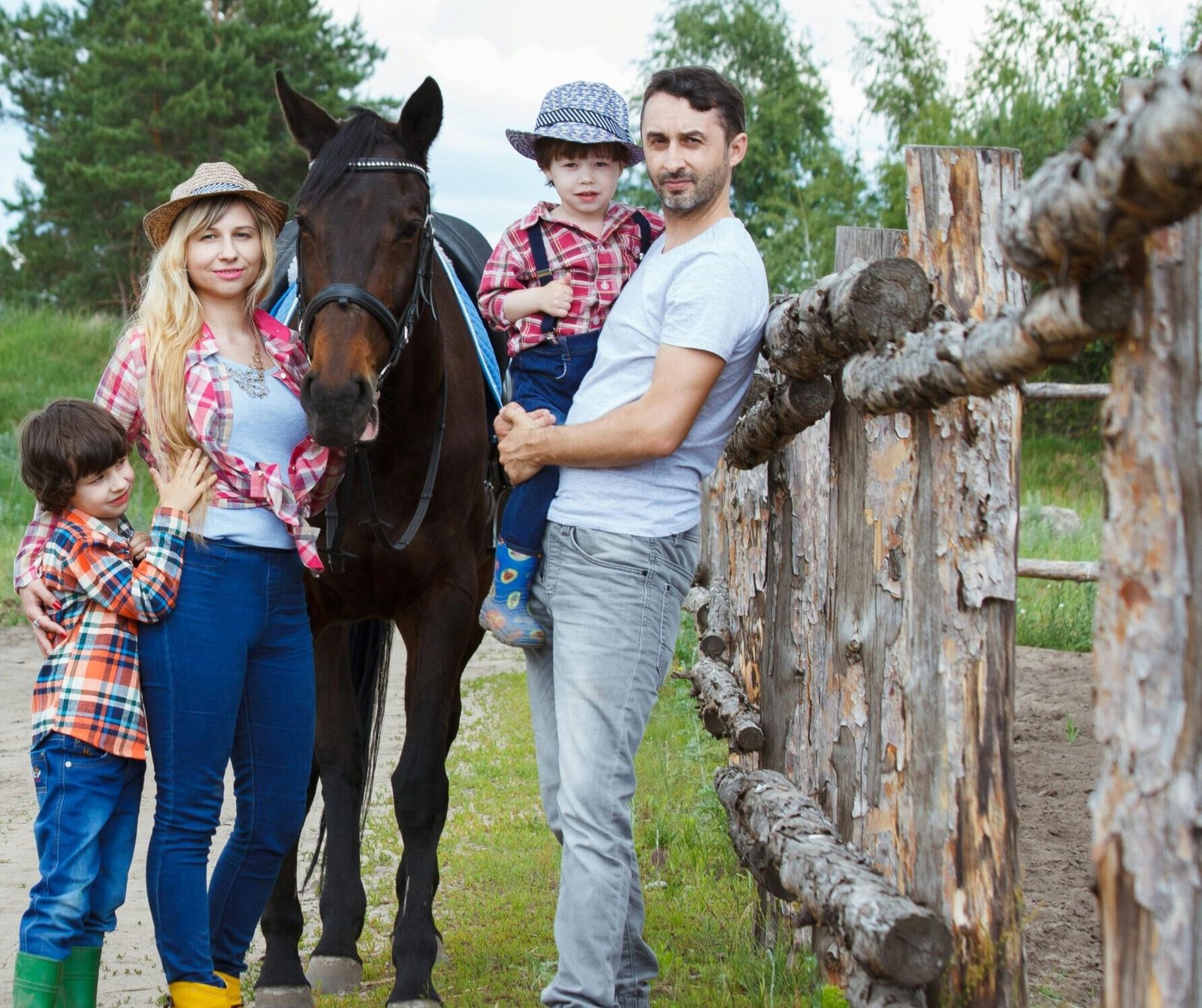 Family bonding outdoors with a horse, capturing joyful moments in a scenic countryside setting.